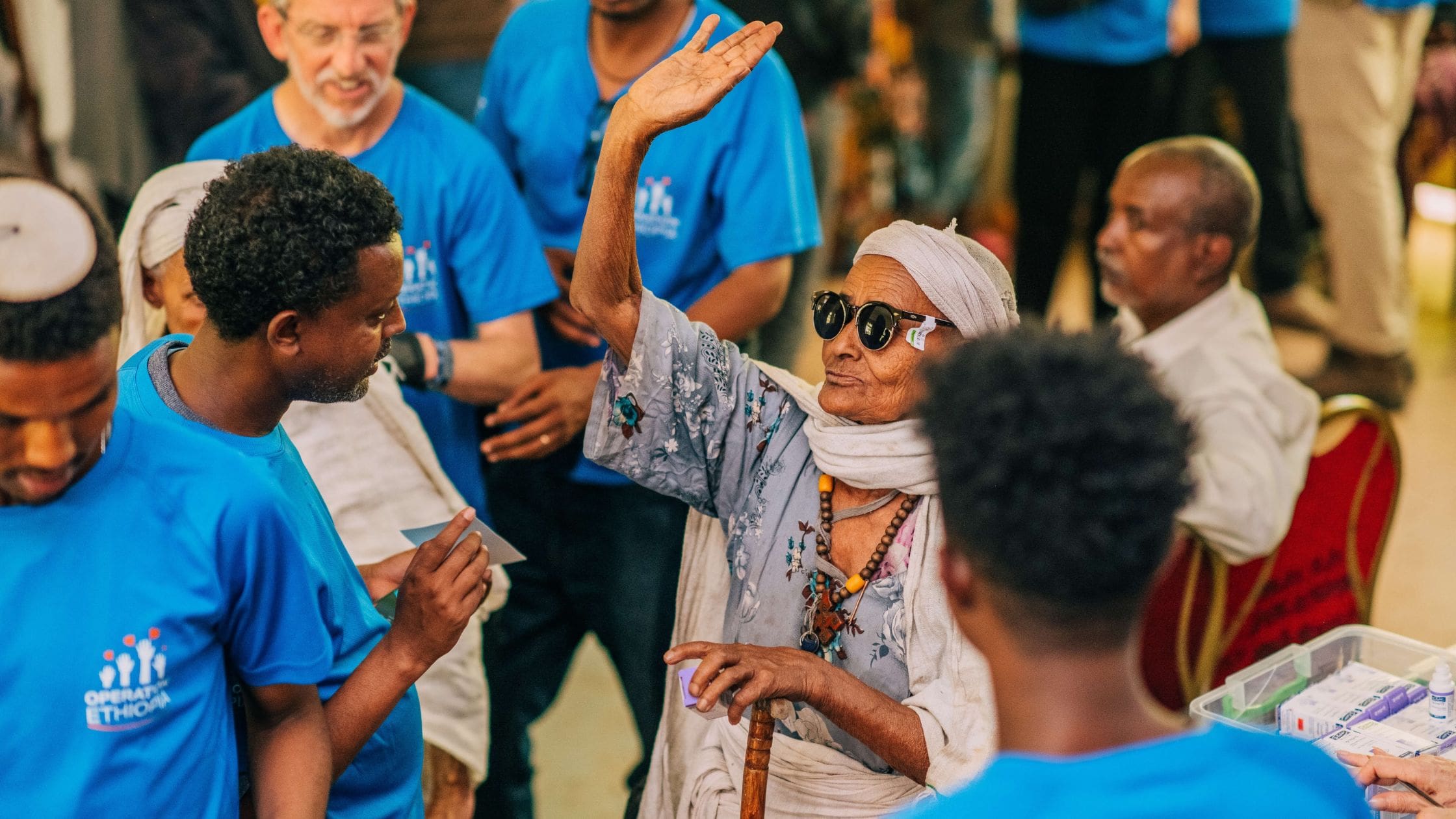 ethiopian woman in sunglasses with hand raised for high five