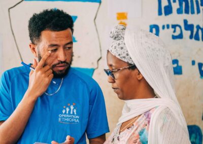 operation ethiopia volunteer helping ethiopian woman with new glasses